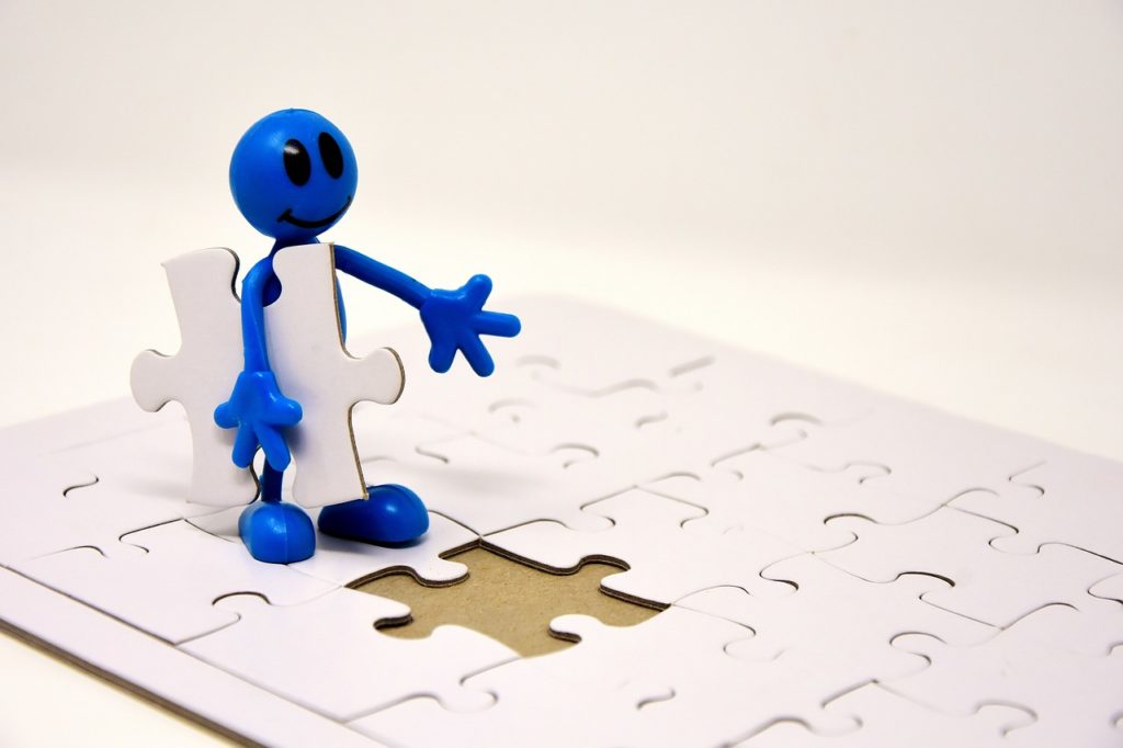 Blue gummy character holding the last piece to complete the whole jigsaw puzzle